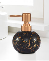 Black marble-patterned soap dispenser with copper pump on a bathroom counter.